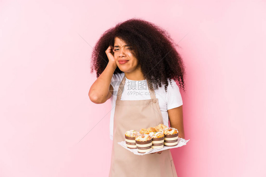 拿着纸杯蛋糕的年轻糕点匠女人孤立了年轻的烤面包师女人图片