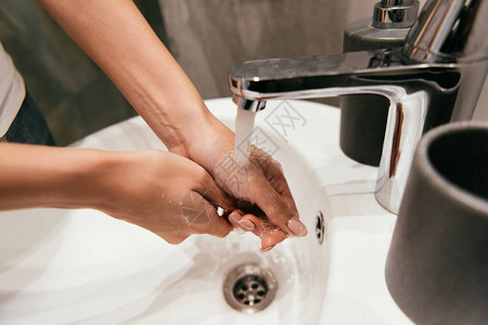 隔离期间在浴室洗手盆中洗手的女图片