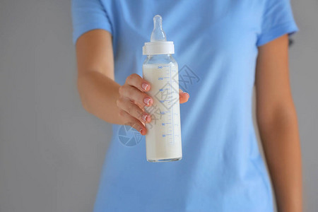 以灰色背景的婴儿牛奶配方奶瓶图片