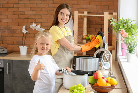 女人和她的小女儿在厨房里洗多功能炊具图片