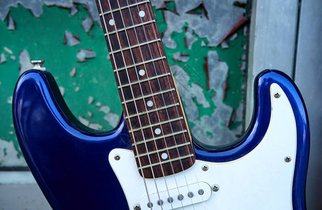 垃圾绿色背景上的蓝色电吉他图片