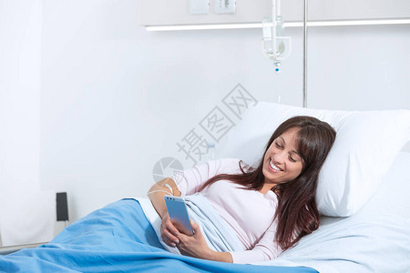 微笑躺在医院床上的女病人图片