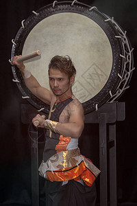 一个日本鼓手Taiko的肖像和一个大鼓的图片