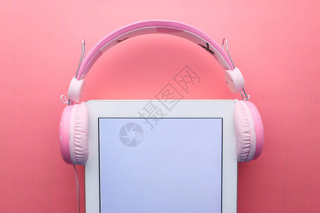 粉红色上的耳机和数字平板图片