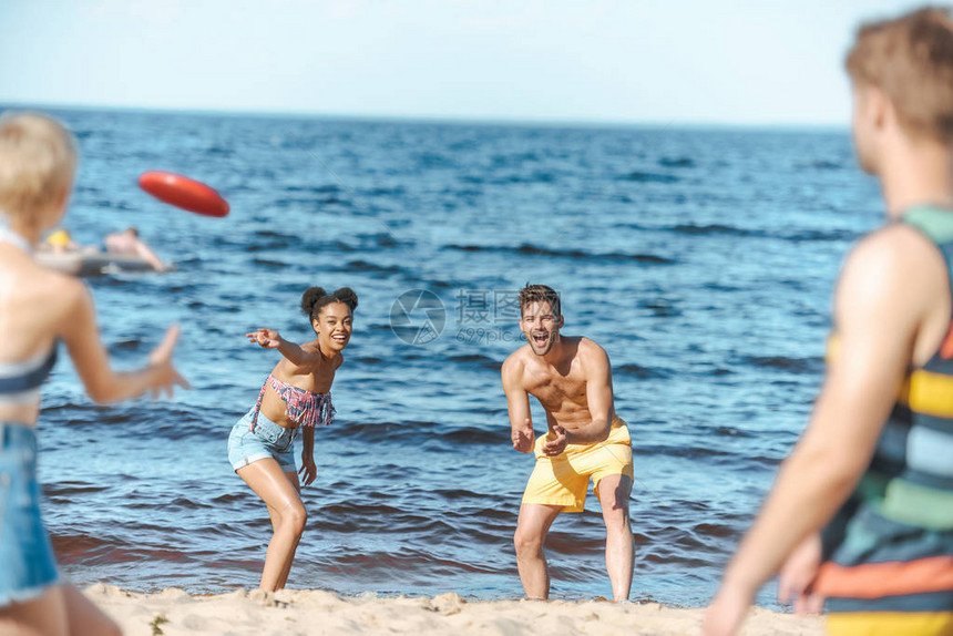 以多种族朋友在海滩上一起玩飞盘的选择图片