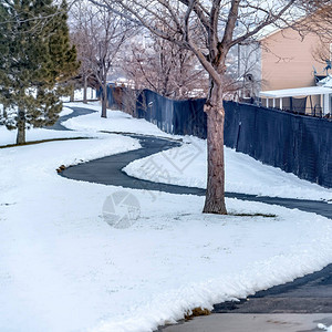 方形框架弯曲的狭窄道路在积雪的地面上在冬天有房子背景图片