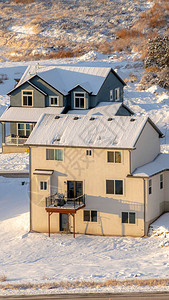 有白雪皑的屋顶和院子的垂直住宅图片