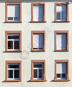 带有窗户和百叶窗的旧城市房屋的正面图片