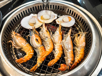 窑炉上的大虾和扇贝海鲜烧烤图片