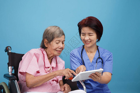 亚洲护士与坐轮椅的老年女病人交图片