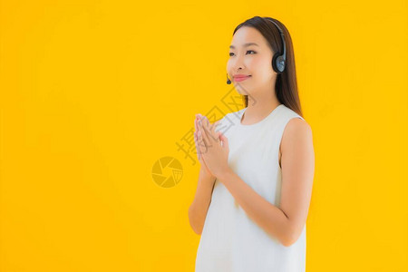 肖像美丽的年轻亚洲女呼叫中心在黄色孤立背图片
