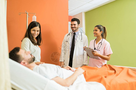 微笑的医生看着男病人和女病人图片