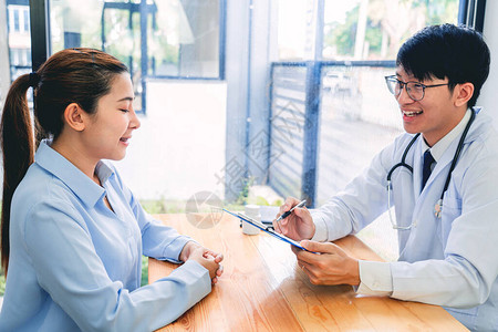 迷人的亚洲男医生在诊所咨询室为女患者提供建议医图片