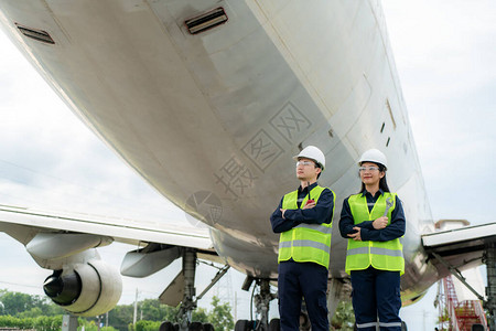 亚洲男女工程师维修飞机臂在前部飞机上交叉图片