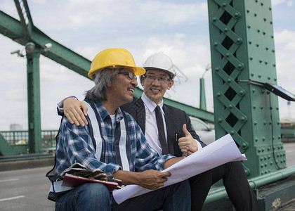 建筑承包商和工程师坐在建筑工地和金属桥上图片