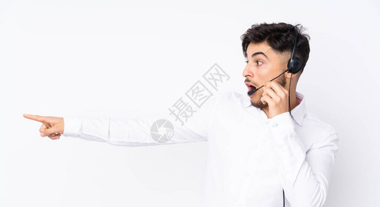 阿拉伯男子手持一只孤立在白色背景上指向另一边的耳头板背景图片