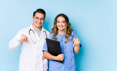 年轻医生夫妇在蓝色背景中装扮与手指隔绝的点数图片