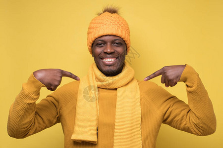 年轻的非洲男子穿着温暖的毛衣围巾和帽子图片