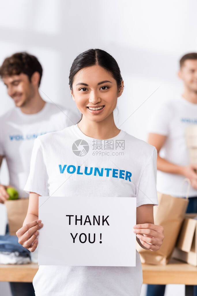 有选择地关注亚洲志愿者持有贺卡的焦点图片