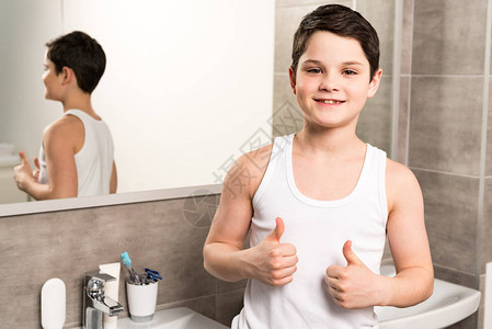 男孩在浴室里站在镜子旁边图片