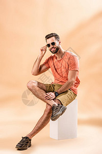 穿着短裤暑假T恤和墨镜的英俊帅男坐在蜜蜂上的图片