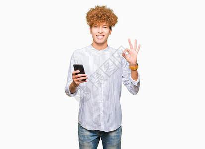 英俊的年轻男子使用智能手机做正确标记用手指图片