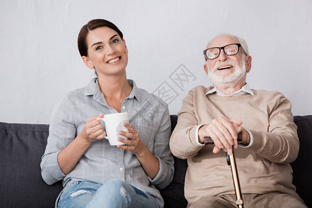 开心的女士和笑的老父亲在沙发上坐图片