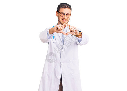 带着熊的帅哥穿着医生制服在爱中微笑用双手做心脏符号形状图片