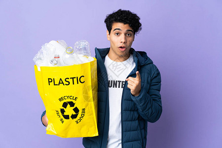 年轻的委内瑞拉男子拿着一个装满塑料瓶的袋子图片