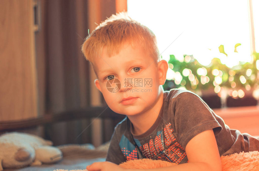 一个可爱的5岁男孩午睡后醒来日落时一个困苦孩子的肖像图片