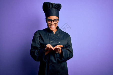身着烹饪制服和帽子的年轻非洲女厨师穿紫底衣图片