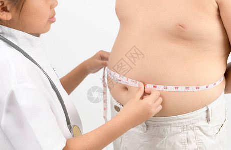 测量肥胖儿童腰部身体脂肪的小医生在白色背景下被隔离图片