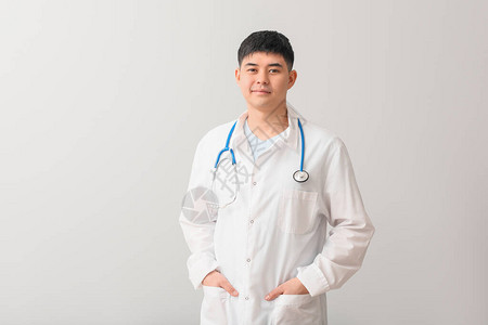 浅色背景的亚洲男医生背景图片