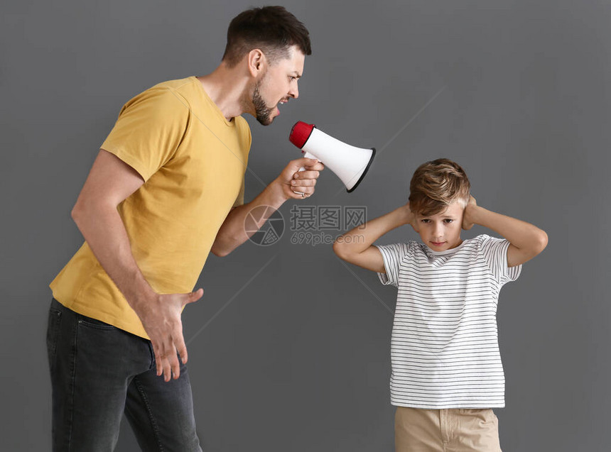小男孩不理他愤怒的父亲却在灰色背图片
