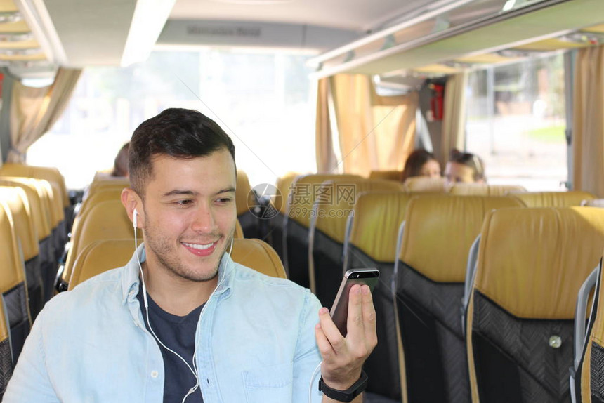 英俊青年男子在公共汽车上用耳机监听音图片