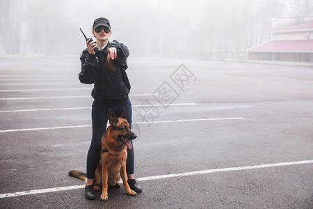 带着狗巡逻城市街道的女警官图片