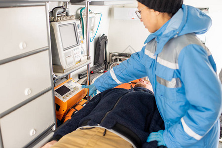 在医疗急救设备上按着统一按键的年轻护理人员图片