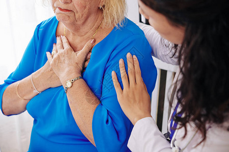 年长妇女在家看医生时抱怨呼吸受苦而图片