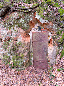 沙石墙上的旧木门碎片覆盖在砂石岩图片