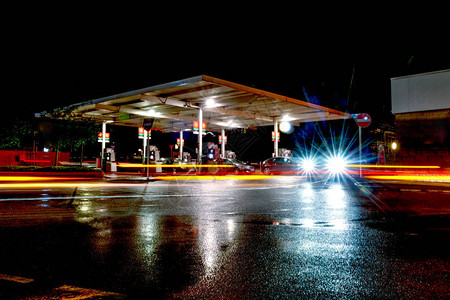 晚上加油站人们满汽油时路过汽车的灯图片