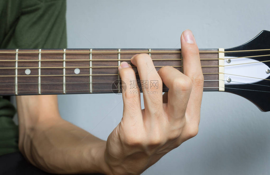 吉他玩家手或音乐手F大和弦在近视中以软自然光显示图片