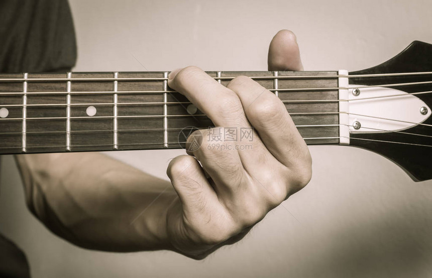 吉他手或音乐家手在原声吉他弦上的G大调和近景中具有图片