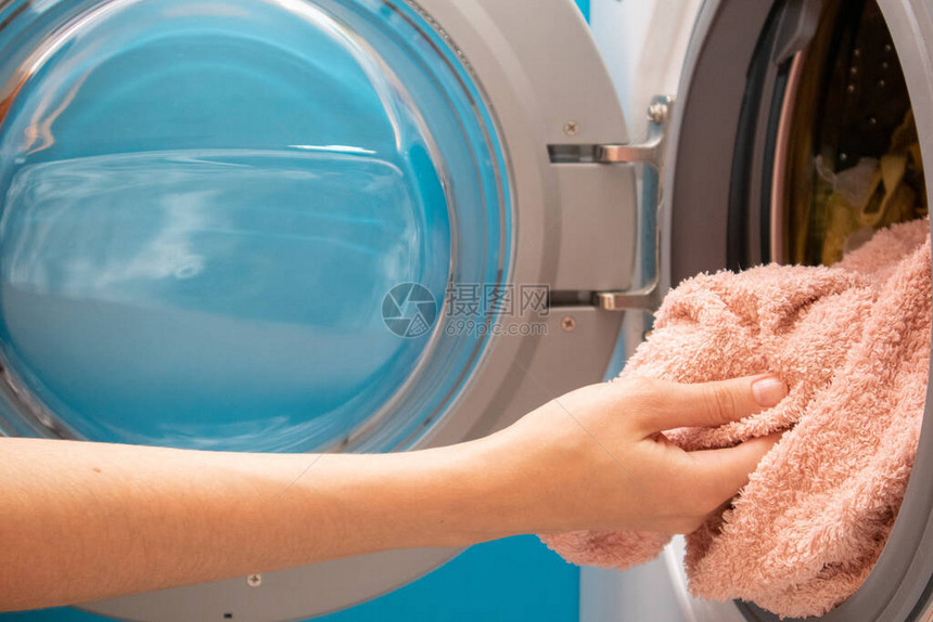 女人的手把衣服放在洗衣机里双手将衣图片