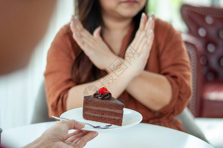 亚洲胖妇女拒绝在饮食期间吃甜食或蛋糕饮食以减肥和改善健图片
