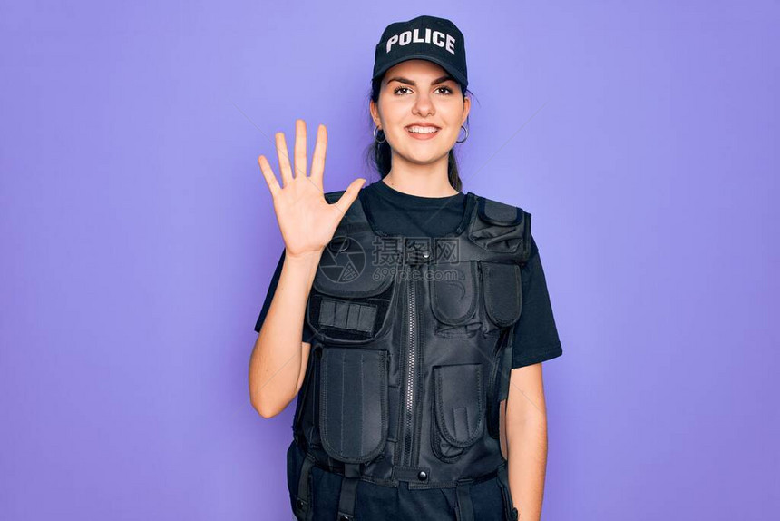 年轻的女警察穿着紫色背景的安全防弹背心制服图片