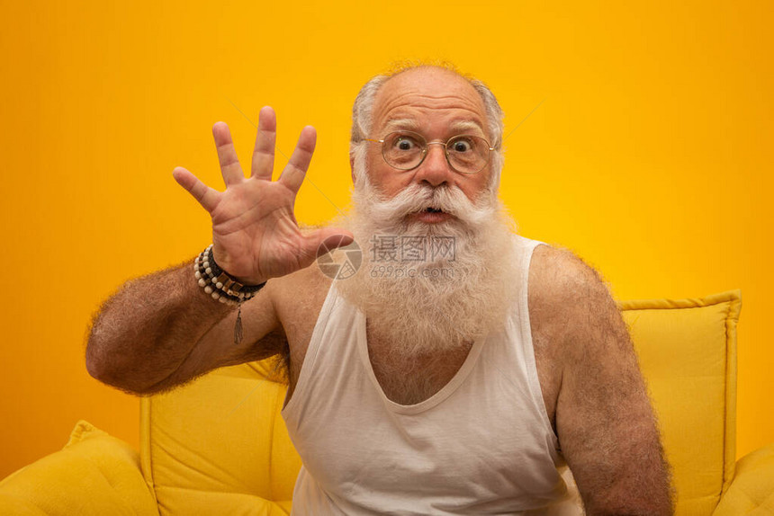 一位长的白胡子男微笑着用手指在黄色背景上做五次手势积极情绪面部表情感受态度图片