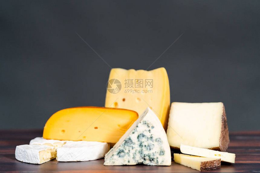 深色木制背景上的各种大美食奶酪楔子图片