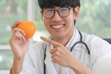 医生或营养师拿着橙子图片