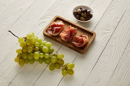 葡萄法式面包上的意大利熏火腿白色木质图片