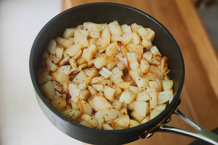 烹饪锅中浅油炸的金薯图片